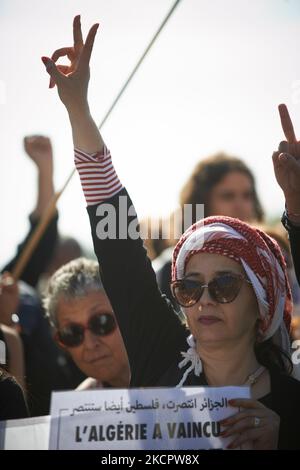 Ein Womab macht das V-Zeichen, während er ein Blatt mit der Aufschrift „Algerien herrschte“ hält. Dutzende von Demonstranten gehen, um den 60.. Jahrestag der Tötung algerischer Demonstranten durch die französische Polizei am 17. 1961. Oktober in Paris zu vermelden. Am 17. 1961. oktober gingen Algerier auf die Straße, um die FLN (Nationale Befreiungsfront) zu unterstützen, die einen Unabhängigkeitskrieg von Frankreich führte. Polizisten intervenierten und töteten mindestens 120 Menschen (durch Ertrinken in der seine oder Erschießen an einem Punkt, an dem nichts schießt). Sie verhafteten mindestens 12.000 Personen und schlugen viele Demonstranten schwer. Auch heute noch, noch die französische Polizei nein Stockfoto