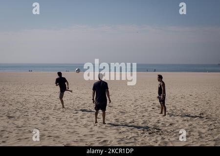 Drei Männer spielen am 18. Oktober 2021 am Strand von Matosinhos, einer Stadt und einer Gemeinde im nördlichen Bezirk Porto in Portugal, mit einem Ball. (Foto von Nikolas Kokovlis/NurPhoto) Stockfoto