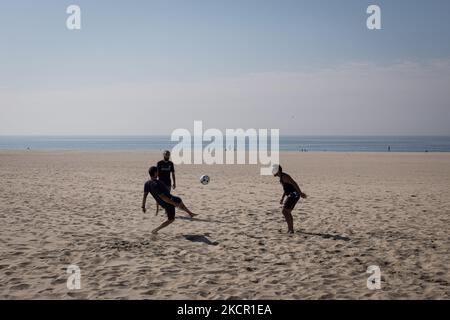 Drei Männer spielen am 18. Oktober 2021 am Strand von Matosinhos, einer Stadt und einer Gemeinde im nördlichen Bezirk Porto in Portugal, mit einem Ball. (Foto von Nikolas Kokovlis/NurPhoto) Stockfoto