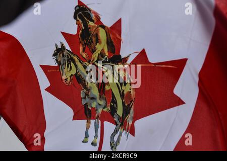 Eine modifizierte kanadische Flagge mit einem Bild eines First Nations-Mitglieds in der Mitte, gesehen in einem „Einwohnerlager“, das aus fünf Tipis, einem Dutzend Zelten und einem heiligen Feuer besteht, das auf dem Gelände der Alberta Legislative aufgestellt wurde. Etwa 50 Menschen waren in dem Lager, das Anfang Oktober begann. Ziel ist es, das Bewusstsein für die Probleme zu schärfen, mit denen sich die First Nations-Gemeinschaften in Alberta und Kanada konfrontiert sehen, einschließlich des Anspruchs auf Territorium und der Frage der unmarkierten Gräber indigener Kinder. Am Freitag, den 22. August 2021, in Alberta Legislature Grounds, Edmonton, Alberta, Kanada. (Foto von Artur Widak/NurPhoto) Stockfoto