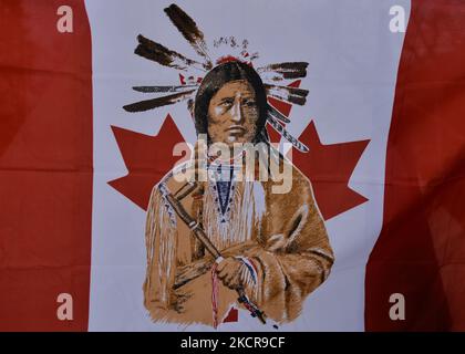 Eine modifizierte kanadische Flagge mit einem Bild eines First Nations-Mitglieds in der Mitte, gesehen in einem „Einwohnerlager“, das aus fünf Tipis, einem Dutzend Zelten und einem heiligen Feuer besteht, das auf dem Gelände der Alberta Legislative aufgestellt wurde. Etwa 50 Menschen waren in dem Lager, das Anfang Oktober begann. Ziel ist es, das Bewusstsein für die Probleme zu schärfen, mit denen sich die First Nations-Gemeinschaften in Alberta und Kanada konfrontiert sehen, einschließlich des Anspruchs auf Territorium und der Frage der unmarkierten Gräber indigener Kinder. Am Freitag, den 22. August 2021, in Alberta Legislature Grounds, Edmonton, Alberta, Kanada. (Foto von Artur Widak/NurPhoto) Stockfoto