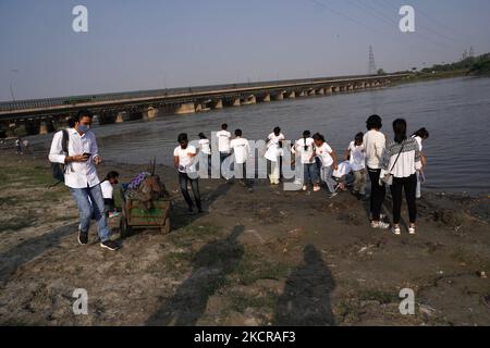 Freiwillige entfernen Plastik und andere Abfälle, während sie am 23. Oktober 2021 an einer Reinigungsfahrt entlang des Flusses Yamuna in Neu-Delhi, Indien, teilnehmen. (Foto von Mayank Makhija/NurPhoto) Stockfoto