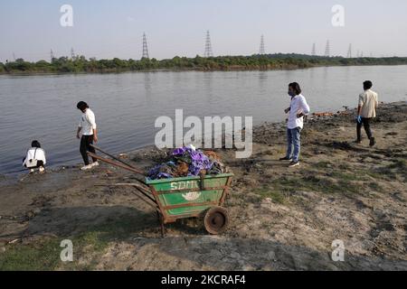 Freiwillige entfernen Plastik und andere Abfälle, während sie am 23. Oktober 2021 an einer Reinigungsfahrt entlang des Flusses Yamuna in Neu-Delhi, Indien, teilnehmen. (Foto von Mayank Makhija/NurPhoto) Stockfoto