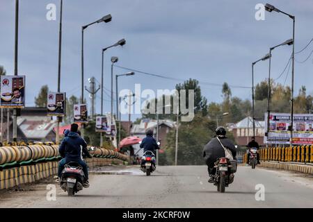 Kashmiri-Biker fahren am 24. Oktober 2021 über eine Brücke in Sopore, Distrikt Baramulla, Jammu und Kashmir, indien. Viele Bewohner behaupteten, dass ihre Zweiräder von Polizeibeamten beschlagnahmt wurden, die ihre Dokumente in Srinagar nicht überprüft haben. (Foto von Nasir Kachroo/NurPhoto) Stockfoto