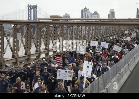 Tausende von Stadtarbeitern marschieren über die Brooklyn Bridge, während das Impfmandat des New Yorker Bürgermeisters Bill de Blasio am 25. Oktober 2021 in New York City, USA, nur wenige Tage vor dem Stichtag ansteht. Das Ende der Woche erteilte Mandat von de Blasio sieht vor, dass Stadtarbeiter mit einer Kündigung konfrontiert werden, wenn sie nicht mindestens eine Dosis eines Anti-Covid-19-Impfstoffs einhalten. Nach dem marsch versammelten sich Demonstranten in der Nähe des Rathauses, wo sie Anti-De Blasio-Slogans skandierten und Solidarität unter allen Stadtarbeitern zeigten. (Foto von John Lamparski/NurPhoto) Stockfoto