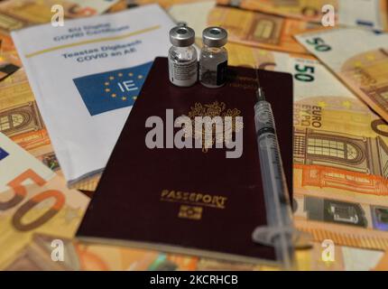 Ein illustratives Bild von fünfzig Euro-Banknoten, einem Reisepass, einem Covid-19-Zertifikat, einer medizinischen Spritze und einer Impfstofffläschchen. Am Montag, den 25. Oktober 2021, Kanada. (Foto von Artur Widak/NurPhoto) Stockfoto