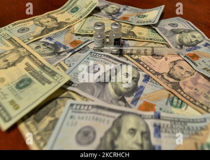 Ein illustratives Bild von US-Dollar-Banknoten, einer medizinischen Spritze und einer Impfstoffflasche. Am Montag, den 25. Oktober 2021, Kanada. (Foto von Artur Widak/NurPhoto) Stockfoto