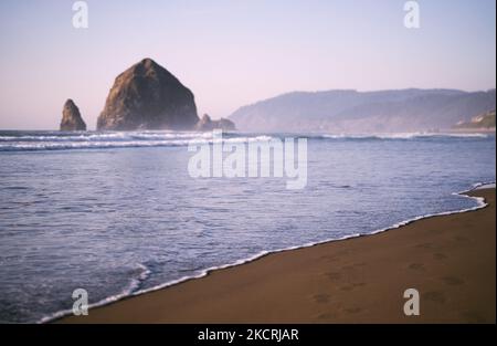 Haystack Rock am Cannon Beach, Oregon, direkt vor Sonnenuntergang Stockfoto