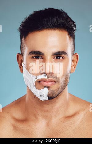 Portrait, Hautpflege und Männerrasur im Studio auf blauem Hintergrund für die Gesichtshaarpflege in Indien. Gesund, Produkte und junge Gesicht Modell rasiert Bart Stockfoto