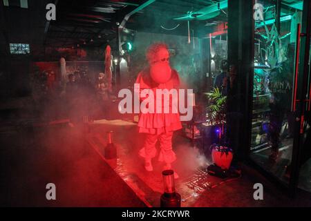 Ein Indonesier nimmt an aufgeführter Tracht Teil, indem er sein Gesicht während der Halloween-Festfeier in einem Café Swasana Food House am 31. Oktober 2021 in Medan, Indonesien, malt. (Foto von Ivan Damanik/NurPhoto) Stockfoto