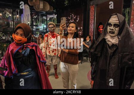 Ein Indonesier nimmt an aufgeführter Tracht Teil, indem er sein Gesicht während der Halloween-Festfeier in einem Café Swasana Food House am 31. Oktober 2021 in Medan, Indonesien, malt. (Foto von Ivan Damanik/NurPhoto) Stockfoto