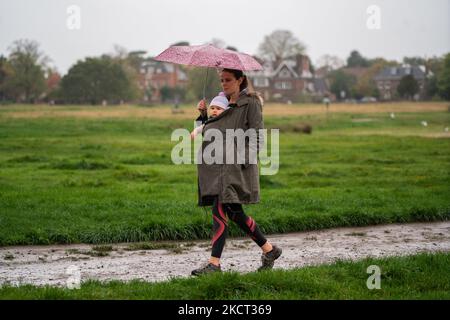 London, Großbritannien. 5. November 2022. Eine Frau mit ihrem Kleinkind, die während Regenschauern unter einem Regenschirm auf einem waterlogged Wimbledon Common South West London untersteht. Eine gelbe Met Office-Warnung vor „anhaltendem und starkem Regen“ mit Überschwemmungsgefahr wurde für Teile Südostenglands und kalte Temperaturen während des Lagerfeuerwochenendes in London und SüdostenglandCredit: amer ghazzal/Alamy Live News ausgegeben Stockfoto