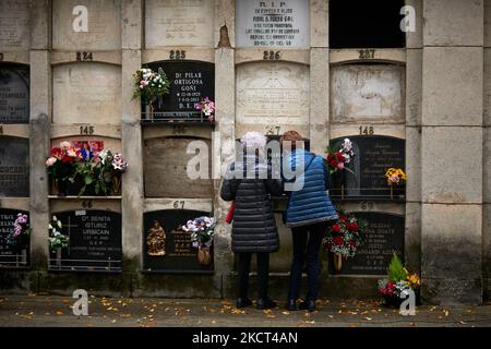 Einige Frauen legten Blumen auf ein Grab, in Pamplona, Spanien, am 1. November 2021 während des Allerheiligen. Wie jedes Jahr haben auch zum Allerheiligen Tausende von Menschen den Friedhof von Pamplona besucht. Mit Blumen und Kerzen haben sie ihre verstorbenen Angehörigen geehrt. (Foto von Iranzu Larrasoana Oneca/NurPhoto) Stockfoto
