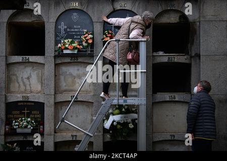 Einige Frauen legten Blumen auf ein Grab, in Pamplona, Spanien, am 1. November 2021 während des Allerheiligen. Wie jedes Jahr haben auch zum Allerheiligen Tausende von Menschen den Friedhof von Pamplona besucht. Mit Blumen und Kerzen haben sie ihre verstorbenen Angehörigen geehrt. (Foto von Iranzu Larrasoana Oneca/NurPhoto) Stockfoto