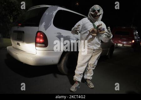 Ein junger Mann mit Overalls und einer Maske vor dem Friedhof von San Pedro, Tláhuac, Dort besuchten und dekorierten Familienmitglieder die Gräber ihrer Angehörigen anlässlich des Tages der Toten in Mexiko während des Gesundheitsnotfalls COVID-19 und der grünen epidemiologischen Ampel in der Hauptstadt. (Foto von Gerardo Vieyra/NurPhoto) Stockfoto