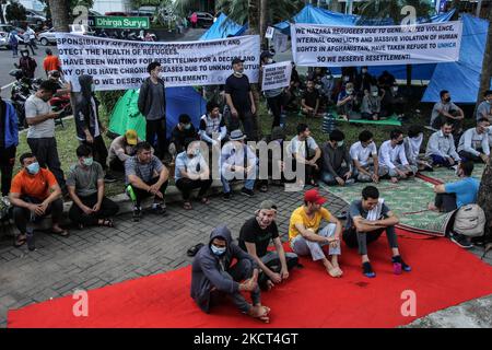 Afghanische Flüchtlinge, die in Indonesien leben, sitzen während eines Protestes in der Nähe von Zelten und übernachten am 2. November 2021 vor dem Repräsentationsbüro des UNHCR in Medan, Indonesien. Die Demonstranten sind afghanische Flüchtlinge, meist Mitglieder der ethnischen Minderheit von Hazara, die die indonesische Regierung auffordert, die Vereinten Nationen, den UNHCR und die IOM dazu zu drängen, eine Neuansiedlung in Drittländern zu schicken und zu fordern. (Foto von Ivan Damanik/NurPhoto) Stockfoto