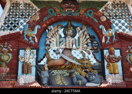 Am 11. Dezember 2011 schmückt eine kunstvolle Schnitzerei der Hindu-Göttin Durga in Form von Mahishasurmardhini (dem Totschläger von Mahishasur) das Tor des Chandshwari-Tempels in Banepa, Nepal. Hier erwürgt Durga den Halbwasserbüffel-Dämonenkönig Mahishasur. Der Legende nach war es Mahishasur, der Himmel und Erde terrorisierte und nach zehn Tagen Kampf besiegten Durga und ihre Armee Mahishasur und töteten ihn. (Foto von Creative Touch Imaging Ltd./NurPhoto) Stockfoto