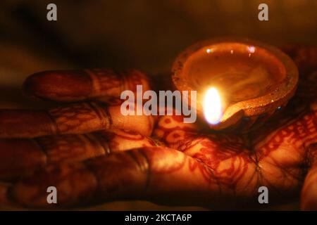 Hindu-Anhänger halten eine Diya (kleine Tonlampe), während sie zuhören, während Gebete während des Festivals von Diwali in einem Hindu-Tempel in Toronto, Ontario, Kanada, am 04. November 2021 rezitiert werden. (Foto von Creative Touch Imaging Ltd./NurPhoto) Stockfoto