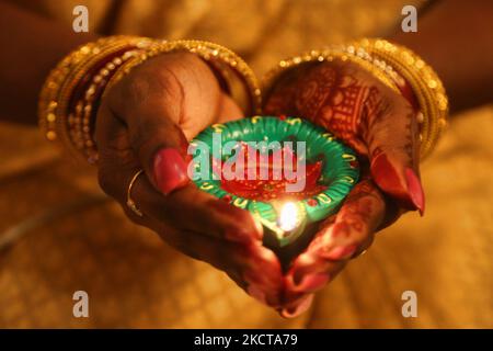 Hindu-Anhänger halten eine Diya (kleine Tonlampe), während sie zuhören, während Gebete während des Festivals von Diwali in einem Hindu-Tempel in Toronto, Ontario, Kanada, am 04. November 2021 rezitiert werden. (Foto von Creative Touch Imaging Ltd./NurPhoto) Stockfoto