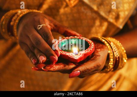 Hindu-Anhänger halten eine Diya (kleine Tonlampe), während sie zuhören, während Gebete während des Festivals von Diwali in einem Hindu-Tempel in Toronto, Ontario, Kanada, am 04. November 2021 rezitiert werden. (Foto von Creative Touch Imaging Ltd./NurPhoto) Stockfoto