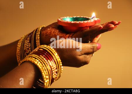 Hindu-Anhänger halten eine Diya (kleine Tonlampe), während sie zuhören, während Gebete während des Festivals von Diwali in einem Hindu-Tempel in Toronto, Ontario, Kanada, am 04. November 2021 rezitiert werden. (Foto von Creative Touch Imaging Ltd./NurPhoto) Stockfoto