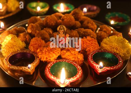 Diyas (kleine Tonlampen) umgeben ein Idol der Göttin Lakshmi (Göttin Laxmi) auf einem Tablett mit Ladoos (indischen Süßigkeiten) während des Festivals von Diwali in einem Hindu-Tempel in Toronto, Ontario, Kanada, am 04. November 2021. (Foto von Creative Touch Imaging Ltd./NurPhoto) Stockfoto
