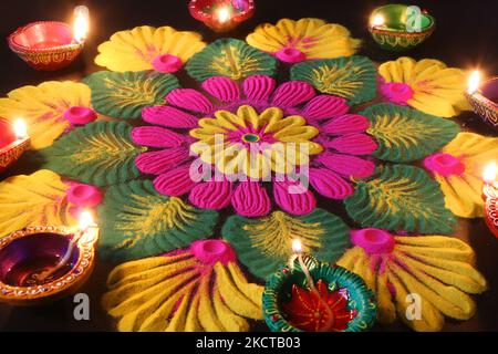 Diyas (kleine Tonlampen) nach einem farbenfrohen Rangloli-Design, das mit farbigem Pulver während des Festivals von Diwali in einem Hindu-Tempel in Toronto, Ontario, Kanada, am 04. November 2021 geschaffen wurde. Rangoli ist ein traditionelles Design, das auf dem Boden mit farbigem Pulver gezeichnet wurde, oft vor Häusern oder Tempeln. (Foto von Creative Touch Imaging Ltd./NurPhoto) Stockfoto