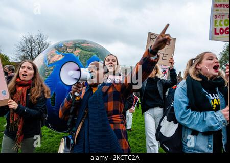 Eine schwarze Frau ruft während eines massiven klimamarsches, der am 6.. November 2021 in Amsterdam organisiert wurde, Slogans gegen den Klimawandel mit einem großen Erdball hinter sich. (Foto von Romy Arroyo Fernandez/NurPhoto) Stockfoto