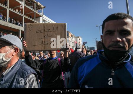 Ein junger Demonstranten hebt ein Plakat auf, das auf Arabisch steht, verdammt über den Putsch, während er an einer Demonstration teilnimmt, die von der Protestbewegung, bekannt als Bürger gegen den Putsch, in der Nähe des Gebäudes des tunesischen Parlaments in der Stadt Bardo in Tunis, Tunesien, am 14. November 2021 veranstaltet wurde. Aus Protest gegen den sogenannten Putsch, der sich auf die vom tunesischen Präsidenten Kais Saied verordneten außergewöhnlichen Maßnahmen bezieht. (Foto von Chedly Ben Ibrahim/NurPhoto) Stockfoto