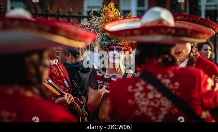 Mariachi Las Adelitas begegnen sich mit einer Figur aus Día de los Muertos. Stockfoto