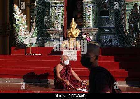 Ein buddhistischer Mönch betet am 18. November 2021 vor einer Buddha-Statue am Vollmondtag des Tazaungmon, dem achten Monat des Myanmar-Kalenders, in der Shwedagon-Pagode in Yangon, Myanmar. (Foto von Myat Thu Kyaw/NurPhoto) Stockfoto