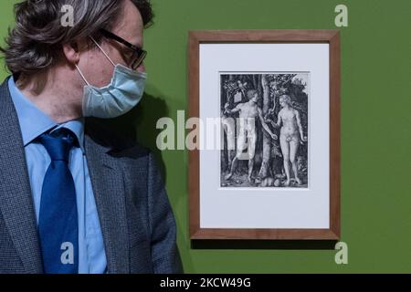 LONDON, VEREINIGTES KÖNIGREICH - 18. NOVEMBER 2021: Ein Mitarbeiter der Galerie betrachtet einen Stich mit dem Titel 'Adam and Eve' (1504) des deutschen Renaissance-Künstlers Albrecht Durer (1471 – 1528) während einer Presseinsicht der Credit Suisse Exhibition Dürers Reisen: Reisen eines Renaissance-Künstlers (20. November 2021 – 27. Februar 2022) in der National Gallery, am 18. November 2021 in London, England. (Foto von Wiktor Szymanowicz/NurPhoto) Stockfoto