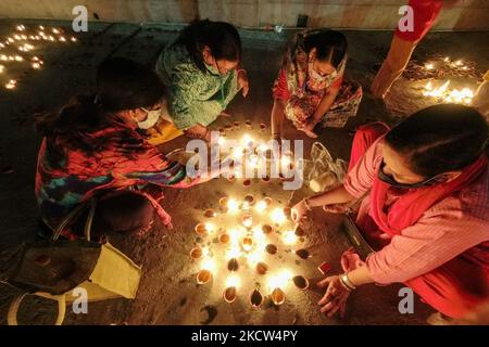 Devotees Licht Erdöllampen anlässlich der Dev Deepavali , an einem Ganges Flussufer in Kalkutta , Indien , am 18. November 2021 .Dev Deepavali oder Diwali der Götter ist ein Festival von Karthik Purnima , gefeiert 15 Tage nach Diwali . Eifrige Anhänger beleuchten irdne Lampen auf Ghats des Flusses Ganges, um den Ganges-Fluss und seine präsidierende Göttin zu ehren. (Foto von Debarchan Chatterjee/NurPhoto) Stockfoto