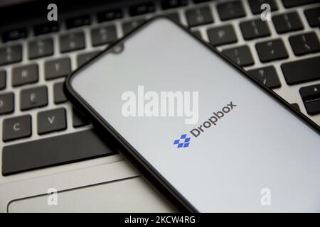 In dieser Abbildung ist ein Dropbox-Logo zu sehen, das am 18. November 2021 in Athen, Griechenland, auf einem Smartphone-Bildschirm mit einem Computerschlüsselwort im Hintergrund angezeigt wird. (Foto von Nikolas Kokovlis/NurPhoto) Stockfoto