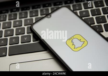 In dieser Abbildung ist ein Snapchat-Logo zu sehen, das am 18. November 2021 in Athen, Griechenland, auf einem Smartphone-Bildschirm mit einem Computerschlüsselwort im Hintergrund angezeigt wird. (Foto von Nikolas Kokovlis/NurPhoto) Stockfoto