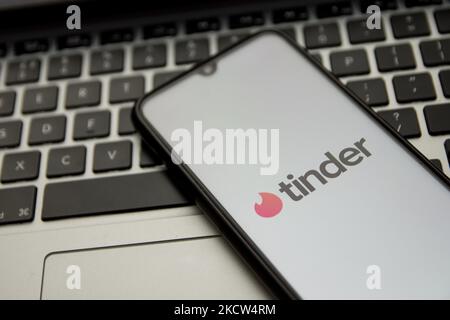 In dieser Abbildung ist ein Tinder-Logo zu sehen, das am 18. November 2021 in Athen, Griechenland, auf einem Smartphone-Bildschirm mit einem Computerschlüsselwort im Hintergrund angezeigt wird. (Foto von Nikolas Kokovlis/NurPhoto) Stockfoto