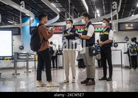 Beamte der Hongkonger Einwanderungsbehörde überprüfen den Pass eines Mannes während einer Anti-Terror-Übung im Hochgeschwindigkeitsbahnhof West Kowloon in Hongkong, 19. November 2021. Die abteilungsübergreifende Einheit für Terrorismusbekämpfung (ICTU) koordinierte heute auf der West-Kowloon-Station in Hongkong eine Übung zur Terrorismusbekämpfung (CT) mit dem Codenamen „TIGERPACE“ (Foto: Vernon Yuen/NurPhoto) Stockfoto