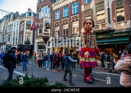 Die kleine Amal geht während ihres Besuchs in Den Haag unter den wachsamen Augen der Menschen, die ihr folgen, durch das Stadtzentrum, um in ganz Europa auf die Not junger Flüchtlinge aufmerksam zu machen, die am 19.. November 2021 aus Syrien geflohen sind. (Foto von Romy Arroyo Fernandez/NurPhoto) Stockfoto