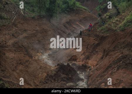 Die Bewohner reparierten Wasserleitungen, die von Erdrutschen getragen wurden, und schnitten den Zugang zur Hauptstraße von Darajat Pass Touristengebiet in Garut Regentschaft ab. Darajat Pass Garut ist ein Touristengebiet mit heißen Quellen im Dorf Padawaas, Garut Regency. Der Erdrutsch am Freitag (19/11/2021) Nachmittag führte dazu, dass der Zugang zum touristischen Gebiet des Darajat-Pass-Kraters abgeschnitten und Dutzende Hektar landwirtschaftlicher Flächen beschädigt wurden. (Foto von Algi Febri Sugita/NurPhoto) Stockfoto