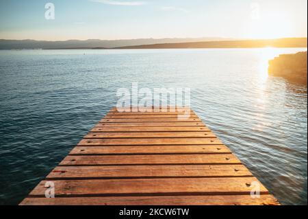 Sommerurlaub in Kroatien. Schöne Tapete. Goldorange Farben. Warmes Abendlicht. Pier am Meer Stockfoto