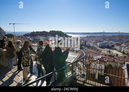 Touristen blicken vom Monte ViewPoint, Lissabon, aus über die Stadt. 18. November 2021. Portugal, das weltweit die Liste der Länder mit den höchsten Covid-19-Impfraten anführt, erwägt neue Beschränkungen, um mit einer möglichen Verschlimmerung der Epidemie, die durch eine Zunahme der Krankenhausaufenthalte und die Anzahl der Fälle gekennzeichnet ist, fertig zu werden. (Foto von Jorge Mantilla/NurPhoto) Stockfoto