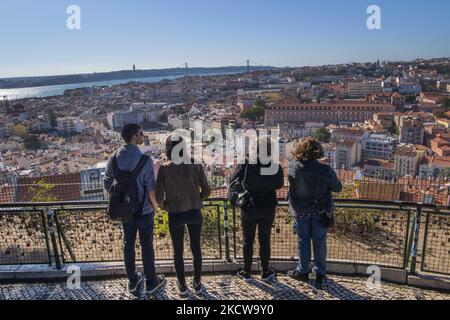 Touristen blicken vom Monte ViewPoint, Lissabon, aus über die Stadt. 18. November 2021. Portugal, das weltweit die Liste der Länder mit den höchsten Covid-19-Impfraten anführt, erwägt neue Beschränkungen, um mit einer möglichen Verschlimmerung der Epidemie, die durch eine Zunahme der Krankenhausaufenthalte und die Anzahl der Fälle gekennzeichnet ist, fertig zu werden. (Foto von Jorge Mantilla/NurPhoto) Stockfoto