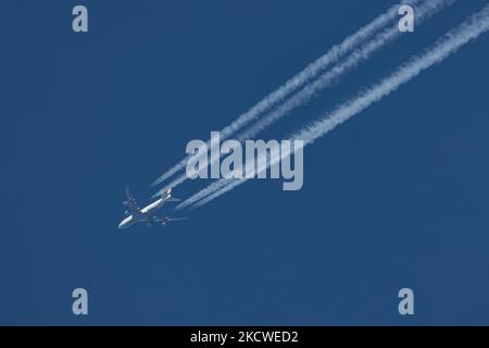 Eine Boeing 747-8 der Lufthansa sah einen Flug vom Flughafen Frankfurt FRA in Deutschland nach Chicago ORD USA in einer Höhe von 34,000 Fuß am blauen Himmel. Das überfliegende Jumbo-Jet-Flugzeug hinterlässt Kondensstreifen oder Kondensstreifen, eine weiße Dampflinie. Das Flugzeug hat die Registrierung D-ABYD, wird von 4x GE-Triebwerken und dem Namen Mecklenburg-Vorpommern angetrieben. Lufthansa DLH, die Flaggonfluggesellschaft Deutschlands und zweitgrößte Fluggesellschaft Europas, ist Gründungsmitglied der Star Alliance. Der Quad Jet wurde monatelang aufgrund der Reisebeschränkungen von Covid geerdet, wurde aber kürzlich wieder in Betrieb genommen Stockfoto