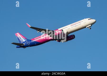 Wizz Air Airbus A321-Flugzeuge, wie sie während des Rollens, des Start- und der Flugphase vom Flughafen Eindhoven WÄHREND eines sonnigen Wintertages am blauen Himmel gesehen werden. W!ZZ Air ist ein ungarischer Ultra Low Cost Airline Carrier mit den größten Stützpunkten am Flughafen Budapest und am Flughafen Luton, der 164 Flughäfen anfliegt. Das Flugzeug A321-200 mit der Logo-Aufschrift auf der Seite hat die Registrierung HA-LXV. Die weltweite Luftfahrtindustrie versucht, sich von den negativen Auswirkungen der Coronavirus-Pandemie Covid-19 zu erholen. Eindhoven, Niederlande am 22. November 2021 (Foto: Nicolas Economou/NurPhoto) Stockfoto