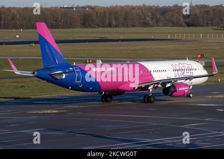 Wizz Air Airbus A321-Flugzeuge, wie sie während des Rollens, des Start- und der Flugphase vom Flughafen Eindhoven WÄHREND eines sonnigen Wintertages am blauen Himmel gesehen werden. W!ZZ Air ist ein ungarischer Ultra Low Cost Airline Carrier mit den größten Stützpunkten am Flughafen Budapest und am Flughafen Luton, der 164 Flughäfen anfliegt. Das Flugzeug A321-200 mit der Logo-Aufschrift auf der Seite hat die Registrierung HA-LXV. Die weltweite Luftfahrtindustrie versucht, sich von den negativen Auswirkungen der Coronavirus-Pandemie Covid-19 zu erholen. Eindhoven, Niederlande am 22. November 2021 (Foto: Nicolas Economou/NurPhoto) Stockfoto