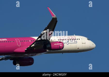 Wizz Air Airbus A321-Flugzeuge, wie sie während des Rollens, des Start- und der Flugphase vom Flughafen Eindhoven WÄHREND eines sonnigen Wintertages am blauen Himmel gesehen werden. W!ZZ Air ist ein ungarischer Ultra Low Cost Airline Carrier mit den größten Stützpunkten am Flughafen Budapest und am Flughafen Luton, der 164 Flughäfen anfliegt. Das Flugzeug A321-200 mit der Logo-Aufschrift auf der Seite hat die Registrierung HA-LXV. Die weltweite Luftfahrtindustrie versucht, sich von den negativen Auswirkungen der Coronavirus-Pandemie Covid-19 zu erholen. Eindhoven, Niederlande am 22. November 2021 (Foto: Nicolas Economou/NurPhoto) Stockfoto