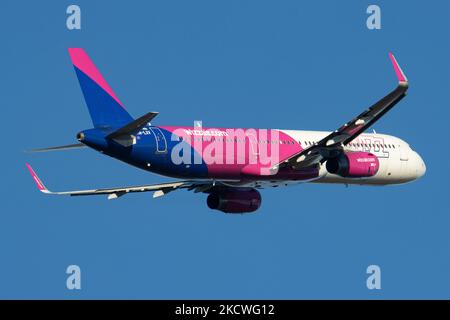 Wizz Air Airbus A321-Flugzeuge, wie sie während des Rollens, des Start- und der Flugphase vom Flughafen Eindhoven WÄHREND eines sonnigen Wintertages am blauen Himmel gesehen werden. W!ZZ Air ist ein ungarischer Ultra Low Cost Airline Carrier mit den größten Stützpunkten am Flughafen Budapest und am Flughafen Luton, der 164 Flughäfen anfliegt. Das Flugzeug A321-200 mit der Logo-Aufschrift auf der Seite hat die Registrierung HA-LXV. Die weltweite Luftfahrtindustrie versucht, sich von den negativen Auswirkungen der Coronavirus-Pandemie Covid-19 zu erholen. Eindhoven, Niederlande am 22. November 2021 (Foto: Nicolas Economou/NurPhoto) Stockfoto