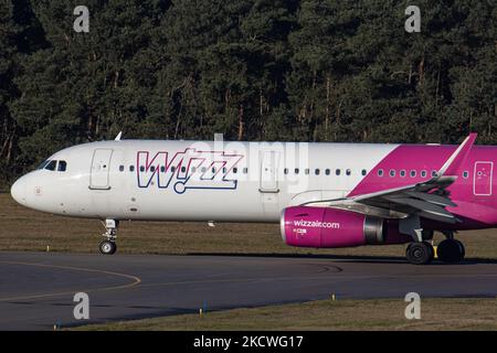 Wizz Air Airbus A321-Flugzeuge, wie sie während des Rollens, des Start- und der Flugphase vom Flughafen Eindhoven WÄHREND eines sonnigen Wintertages am blauen Himmel gesehen werden. W!ZZ Air ist ein ungarischer Ultra Low Cost Airline Carrier mit den größten Stützpunkten am Flughafen Budapest und am Flughafen Luton, der 164 Flughäfen anfliegt. Das Flugzeug A321-200 mit der Logo-Aufschrift auf der Seite hat die Registrierung HA-LXV. Die weltweite Luftfahrtindustrie versucht, sich von den negativen Auswirkungen der Coronavirus-Pandemie Covid-19 zu erholen. Eindhoven, Niederlande am 22. November 2021 (Foto: Nicolas Economou/NurPhoto) Stockfoto