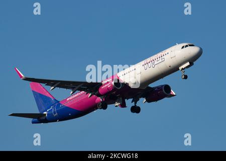 Wizz Air Airbus A321-Flugzeuge, wie sie während des Rollens, des Start- und der Flugphase vom Flughafen Eindhoven WÄHREND eines sonnigen Wintertages am blauen Himmel gesehen werden. W!ZZ Air ist ein ungarischer Ultra Low Cost Airline Carrier mit den größten Stützpunkten am Flughafen Budapest und am Flughafen Luton, der 164 Flughäfen anfliegt. Das Flugzeug A321-200 mit der Logo-Aufschrift auf der Seite hat die Registrierung HA-LXV. Die weltweite Luftfahrtindustrie versucht, sich von den negativen Auswirkungen der Coronavirus-Pandemie Covid-19 zu erholen. Eindhoven, Niederlande am 22. November 2021 (Foto: Nicolas Economou/NurPhoto) Stockfoto