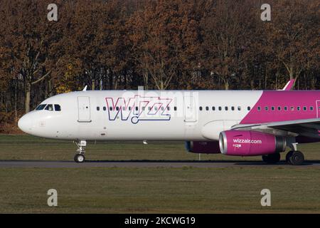 Wizz Air Airbus A321-Flugzeuge, wie sie während des Rollens, des Start- und der Flugphase vom Flughafen Eindhoven WÄHREND eines sonnigen Wintertages am blauen Himmel gesehen werden. W!ZZ Air ist ein ungarischer Ultra Low Cost Airline Carrier mit den größten Stützpunkten am Flughafen Budapest und am Flughafen Luton, der 164 Flughäfen anfliegt. Das Flugzeug A321-200 mit der Logo-Aufschrift auf der Seite hat die Registrierung HA-LXV. Die weltweite Luftfahrtindustrie versucht, sich von den negativen Auswirkungen der Coronavirus-Pandemie Covid-19 zu erholen. Eindhoven, Niederlande am 22. November 2021 (Foto: Nicolas Economou/NurPhoto) Stockfoto